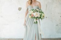 an elegant pastel green off the shoulder wedding dress with a draped bodice and a pleated skirt plus a front slit and a train