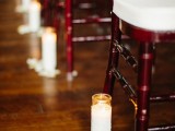 white candles in tall glasses and white petals are a nice decor idea for a wedding aisle, this is timeless classics that fits most of weddings