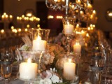 a chic formal wedding tablescape with a tall candelabra, glass candleholders and white blooms looks very charming and very inviting