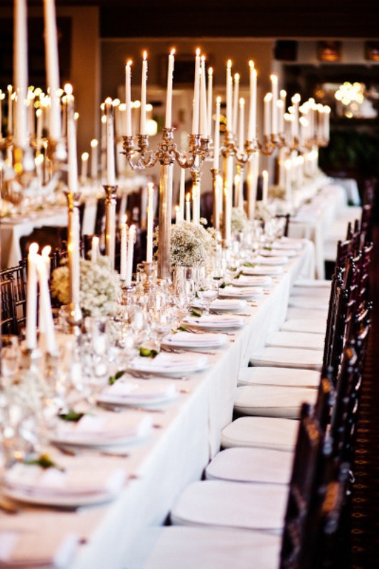 a refined neutral wedding tablescape with neutral blooms, tall candelabras with tall and thin candles is a lovely idea for a formal wedding