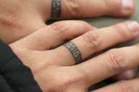 Chic ring-imitating tattoos containing your wedding date done in Roman numbers