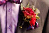 a bold and stylish groom’s outfit with a brown blazer, a pink gingham shirt, a bright floral bow tie and a bold handkerchief and boutonniere