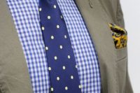 a bold groom’s look with a blue checked shirt, a navy and yellow polka dot tie, a yellow boutonniere and a handkerchief