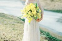 a bold yellow wedding bouquet with greenery is a bright accent to highlight your wedding look