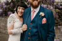 a bright blue tweed three-piece suit, a white shirt and a pink tie and handkerchief plus a chain and amber buttons