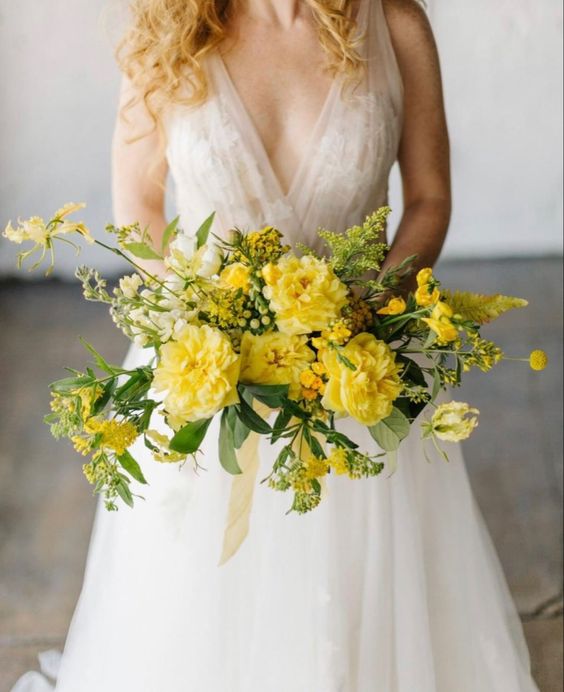 a bright yellow wedding bouquet with a dimension and a texture plus some ribbon is amazing for spring