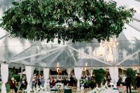 a classic black and white floor with a super lush greenery chandelier over it is a gorgeous idea for a classic wedding with plenty of greenery