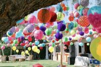 a colorful and fun fiesta wedding lounge with lots of bright balloons, paper pompoms and lanterns is all fun and joy