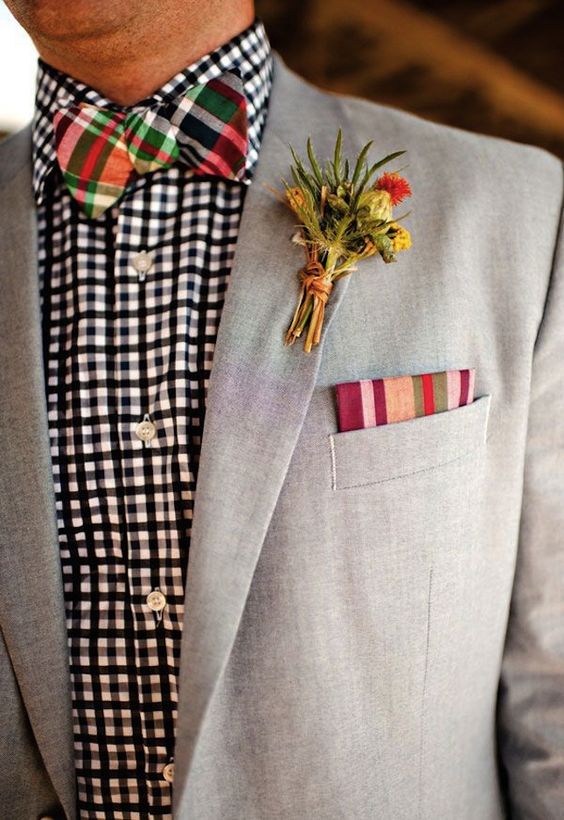 a colorful groom's look with a black and white checked shirt, a colorful checked bow tie, a dove grey blazer and a striped handkerchief
