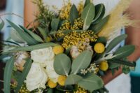 a cool wedding bouquet with billy balls, mimosas, white roses, foliage and a king protea plus pampas grass for summer