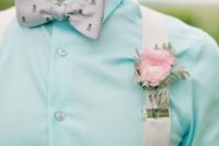 a creative and fresh spring look with a turquoise shirt, neutral suspenders and a printed skull bow tie for a touch of whimsy