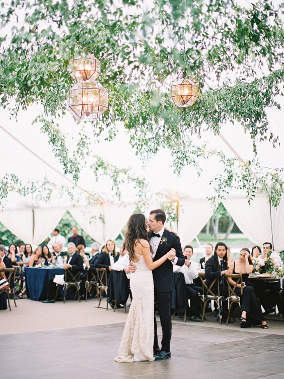 a dance floor styled with greenery garlands and faceted lanterns over it is a lovely and chic space for having fun