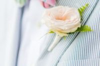 a dreamy and airy groom’s look with a blue thin striped blazer, a white shirt, a bold checked bow tie and a blush boutonniere