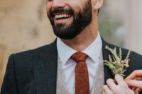 a fall boho groom’s outfit with a white shirt, a grey waistcoat, a graphite grey blazer and a rust skinny tie plus a greenery boutonniere