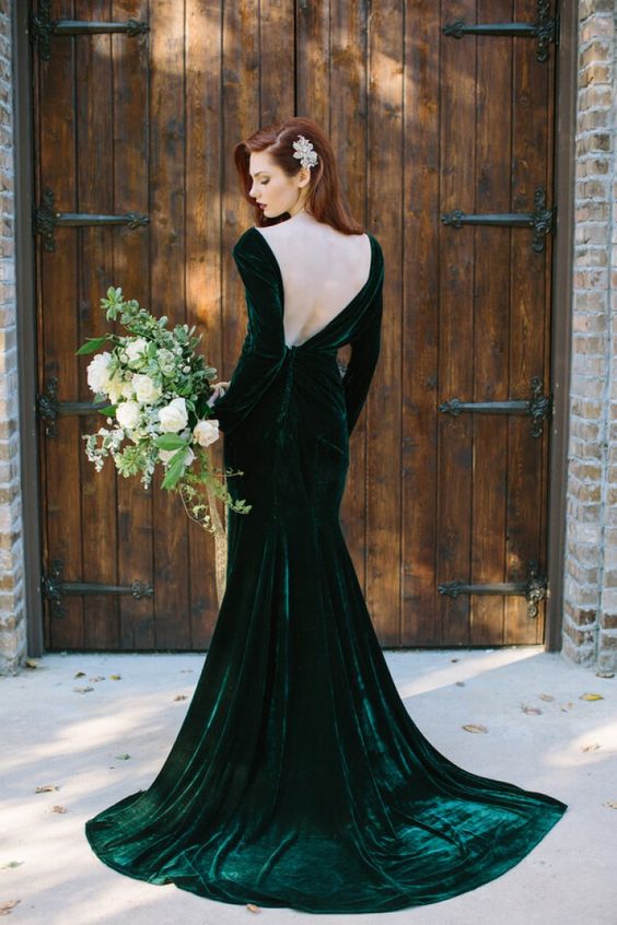 a gorgeous emerald green velvet wedding dress with a mermaid silhouette and a cutout back plus long sleeves
