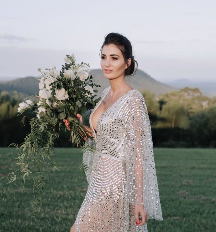 a gorgeous modern silver wedding dress with a nude underdress, wide sleeves and a plunging neckline and large sequins