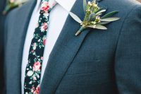 a graphite grey suit, a white shirt, a moody floral tie and a greenery boutonniere are a nice combo for a fall wedding, the floral tie brings interest to the look
