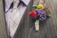 a grey striped three-piece suit, a lilac gingham shirt, a grey and white checked tie and a bold floral boutonniere