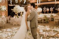 a jaw-dropping dance floor with lights and greenery under the glass dance floor and lights, greenery and white blooms over the space