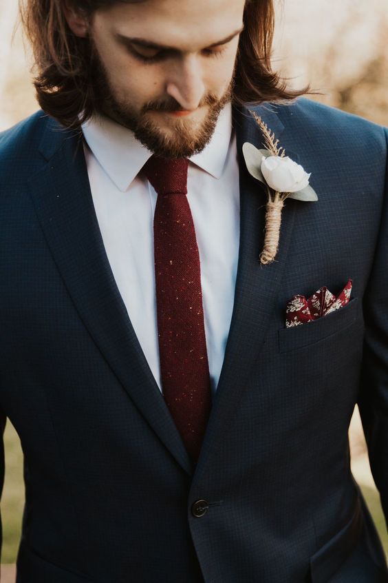a navy pantsuit, a white shirt, a burgundy skinny tie and a matching burgundy handkerchief, a white floral boutonniere for the fall