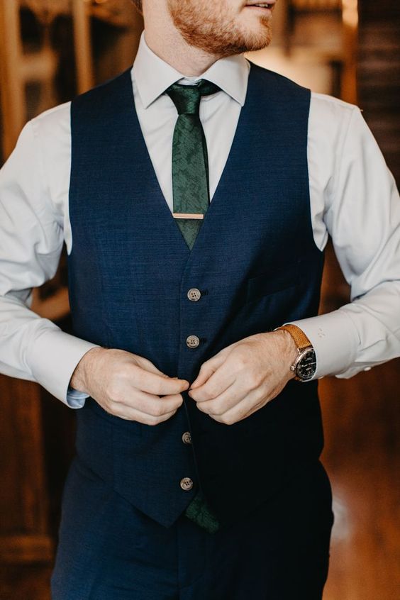 a navy suit with a waistcoat, a white shirt and a green skinny tie with a snakeskin print is an elegant and chic idea for a wedding