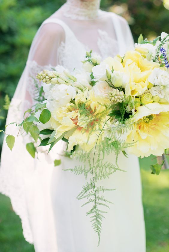 a pale yellow wedding bouquet with oversized tulips in white and yellow, some spring bulbs and greenery is wow