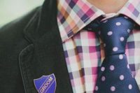 a pretty and bright groom’s outfit with a colorful checked shirt, a navy and pink polka dot tie and a black blazer
