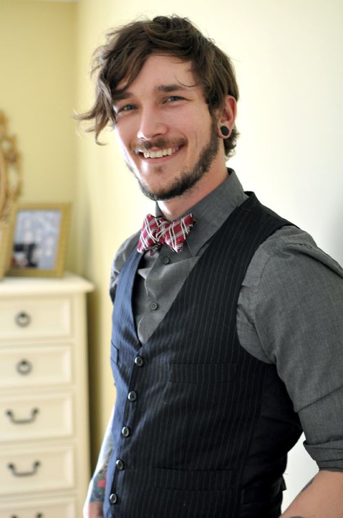 a pretty groom's outfit with a grey shirt, a black striped waistcoat and a red checked bow tie is all cool
