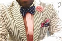 a pretty groom’s outfit with a striped blazer, a pink shirt, a navy checked bow tie and a bright blue and pink handkerchief