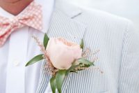 a relaxed and airy groom’s outfit with a thin striped blazer, a white shirt and a pink checked bow tie plus a pink peony rose boutonniere