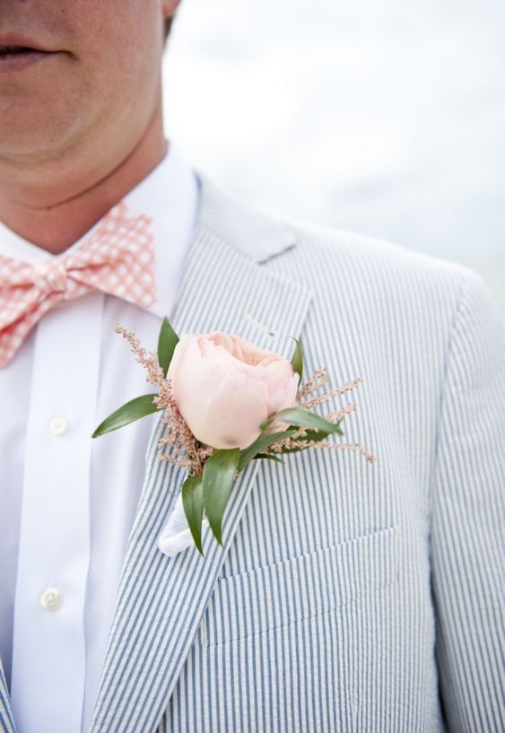 a relaxed and airy groom's outfit with a thin striped blazer, a white shirt and a pink checked bow tie plus a pink peony rose boutonniere