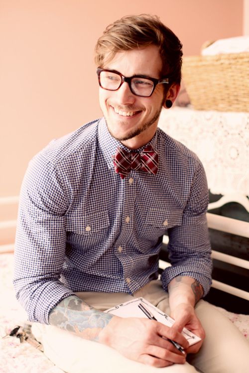 a relaxed and pretty groom's look with a blue gingham shirt, a red checked bow tie and white jeans is cool