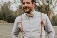 a rustic groom’s look with an off-white shirt, terracotta pants, amber leather suspenders and a printed bow tie