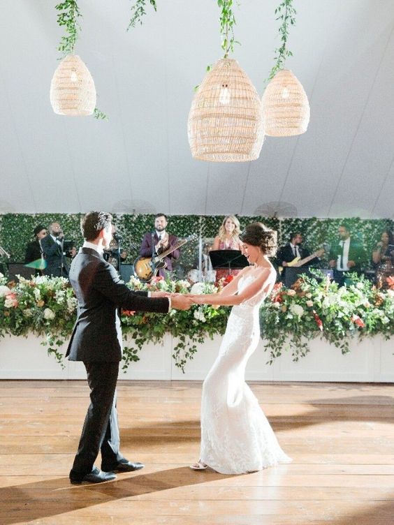 a simple dance floor with woven pendant lamps hanging on greenery is amazing for a more relaxed wedding with greenery decor