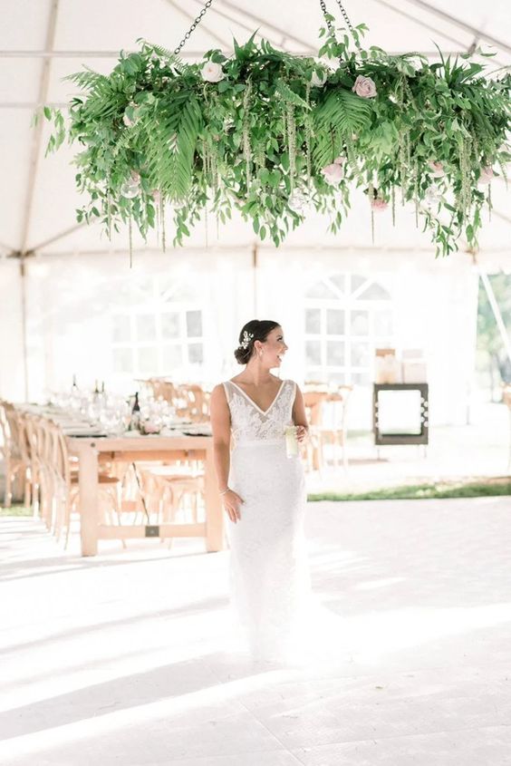 a simple white dance floor with a greenery chandelier and neutral blooms is a great idea for a non floral wedding