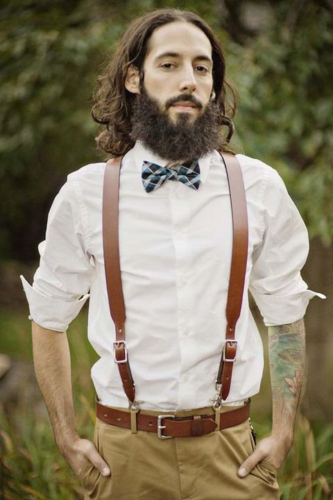 a stylish outfit with a white shirt, wide brown leather suspenders, a matching belt, a printed bow tie and tan pants