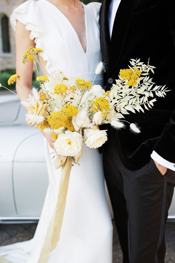 a stylish wedding bouquet of neutral peony roses, mimosas, white dried leaves and grasses is a statement idea for the fall