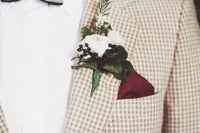 a tan houndstooth print blazer, a white shirt, a black and gold striped bow tie and a white flower boutonniere