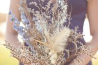 a wedding bouquet of dried herbs, feathers, blue blooms looks ethereal and unique