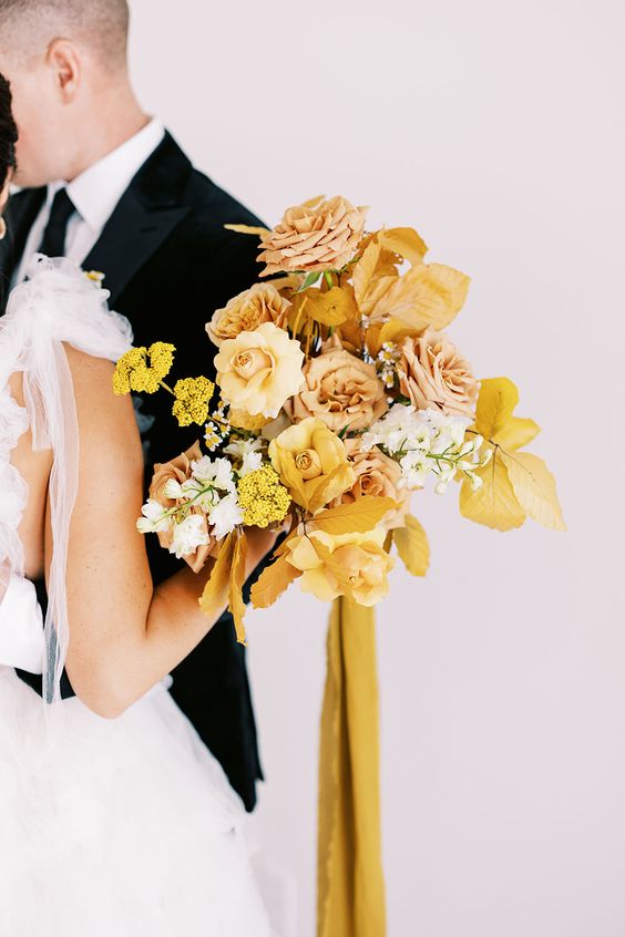 a yellow wedding bouquet with roses, peony roses, mimosas, fall leaves and mustard ribbons is a cool idea for the fall