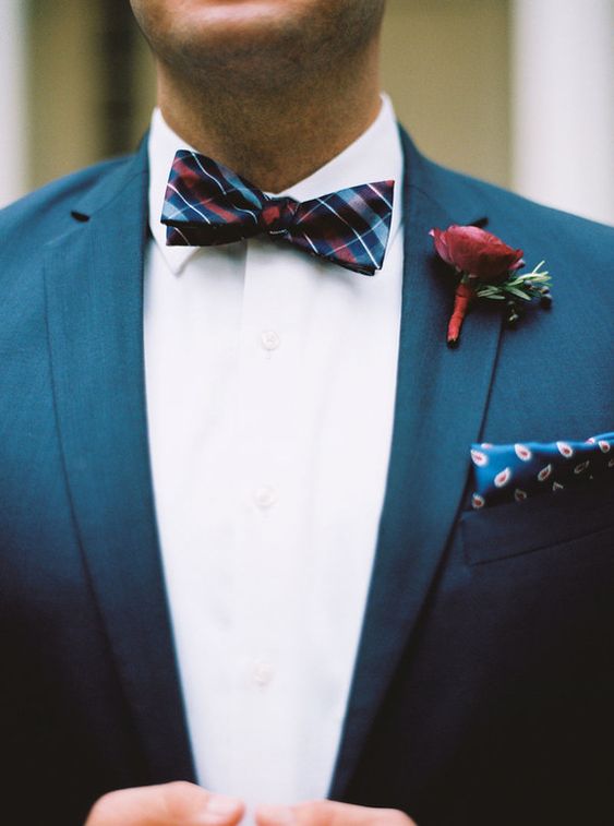 an elegant groom's outfit with a white shirt, a navy blazer, a dark checked bow tie and a printed handkerchief is chic