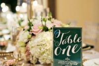 an emerald table number and a matching napkin paired with gold touches will give your tablescape a glam look