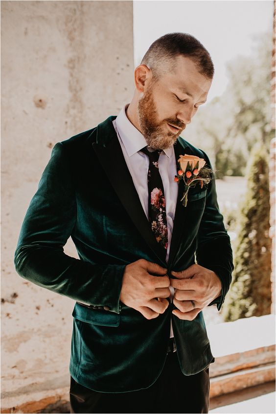brown pants, a white shirt, a moody floral tie, an emerald velvet blazer and a large floral boutonniere are amazing for fall