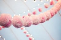 lights and garlands of pink paper pompoms add an airy and romantic feel to the wedding tent