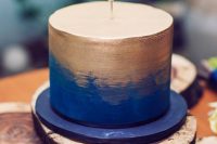 a bold blue and gold wedding cake with a cool wire topper is a fun and cheerful option
