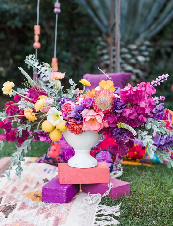 a bold spring wedding centerpiece in hot pink, purple, yellow and with lemons looks wow