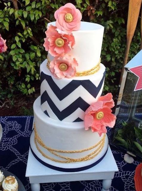 a bold wedding cake with white, black adn white chevron tiers, gold roper and pink blooms is a lovely idea for a modern wedding