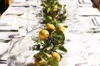 a bright citrus wedding table runner of lemons and limes and greenery is a very cool and summer-like idea
