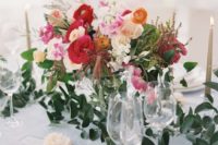 a bright spring wedding centerpiece in white, pink, hot red and orange plus greenery