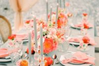 a bright wedding tablescape with a mint tablecloth, mint candles, coral napkins and blooms, orange flowers and apples looks wow